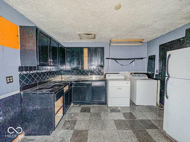 kitchen with a textured ceiling, washer / clothes dryer, and backsplash