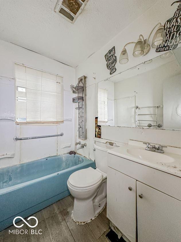 full bathroom with a textured ceiling, toilet, wood finished floors, vanity, and visible vents