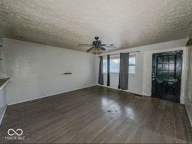 unfurnished living room featuring a ceiling fan, a textured ceiling, and wood finished floors