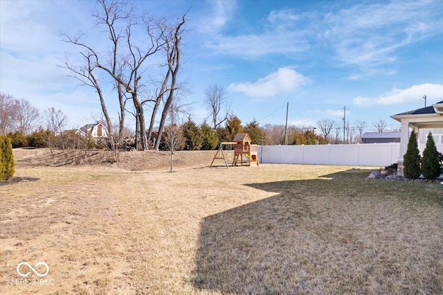 view of yard featuring fence and a playground