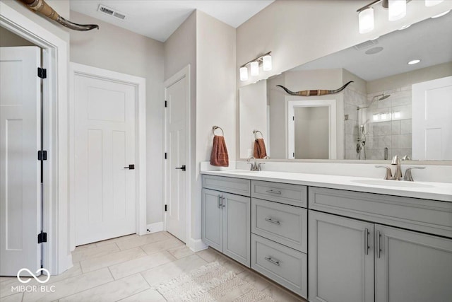 full bathroom with a sink, visible vents, a stall shower, and double vanity