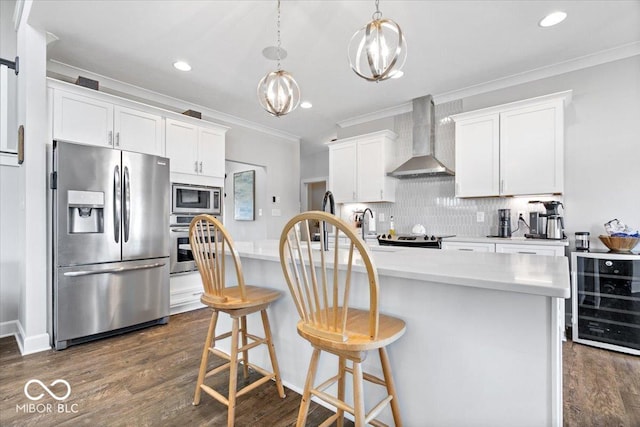 kitchen with ornamental molding, backsplash, wine cooler, appliances with stainless steel finishes, and wall chimney exhaust hood