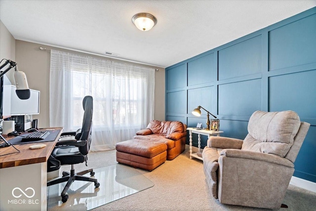 office with a decorative wall, carpet, and visible vents