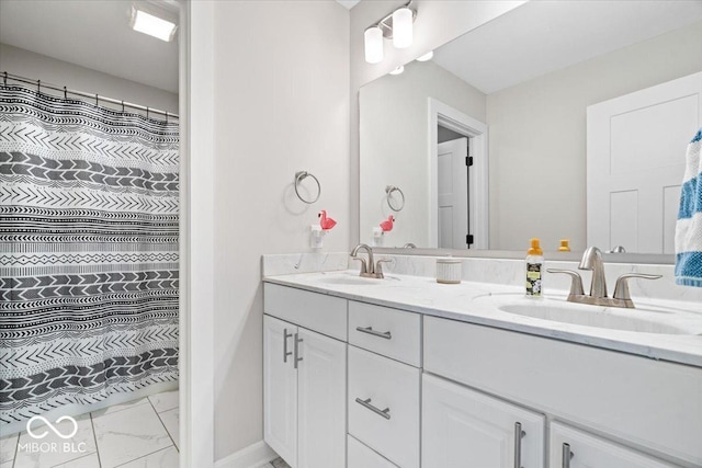 full bathroom featuring double vanity, baseboards, marble finish floor, and a sink