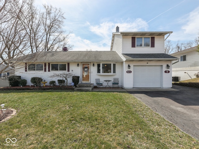 traditional-style house with a front yard, central AC, a chimney, a garage, and aphalt driveway