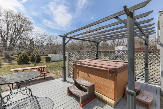 deck with a storage unit, an outbuilding, outdoor dining space, a pergola, and a hot tub