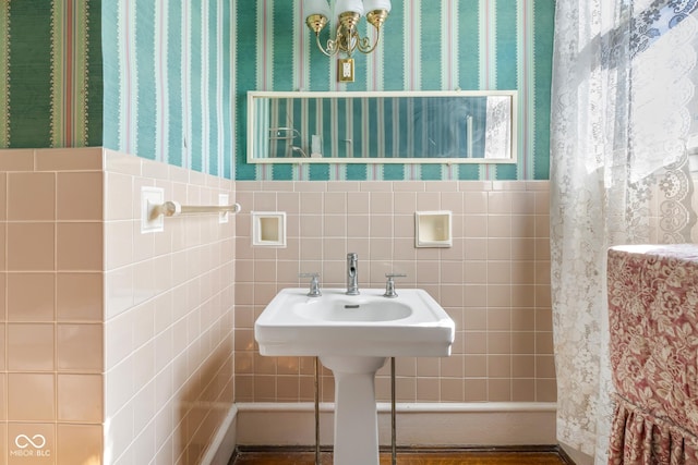 bathroom featuring a wainscoted wall, tile walls, and wallpapered walls