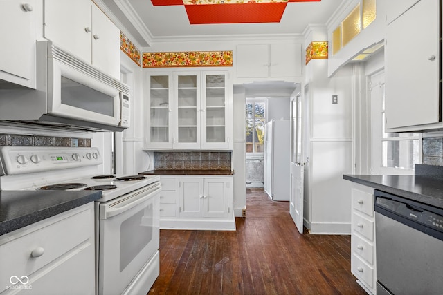 kitchen featuring white appliances, dark countertops, tasteful backsplash, and white cabinetry