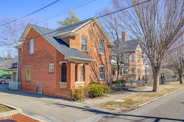 view of front of home with fence, brick siding, central AC, and a shingled roof