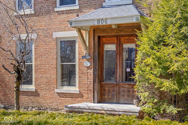 property entrance featuring brick siding