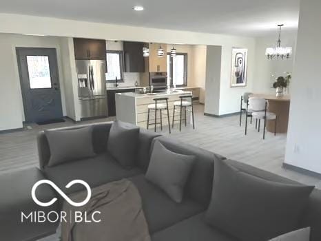 living room featuring an inviting chandelier and baseboards