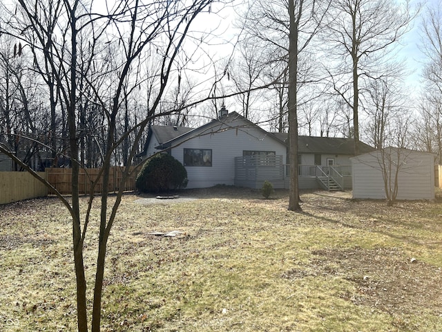 exterior space featuring a storage shed, an outdoor structure, fence, and a chimney