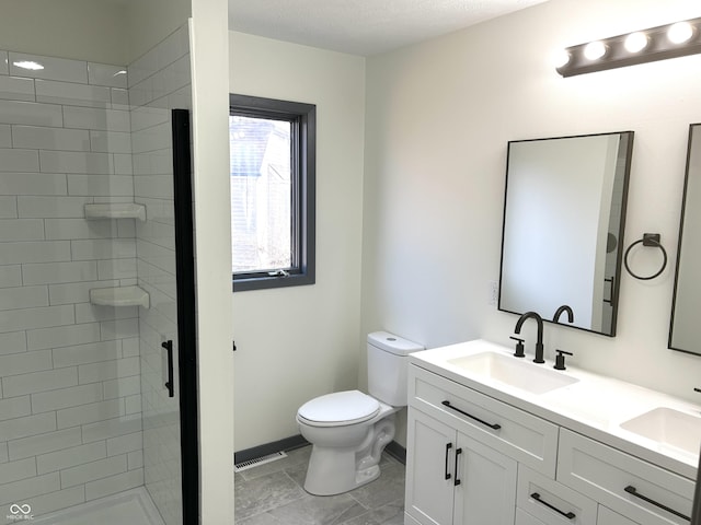 bathroom featuring a shower stall, toilet, baseboards, and a sink