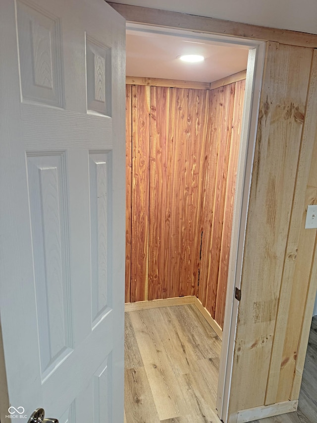 interior details featuring wood finished floors and wood walls