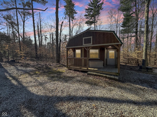 view of front of home with a gambrel roof and an outbuilding