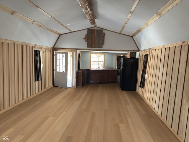 additional living space with vaulted ceiling, light wood-style flooring, and a sink