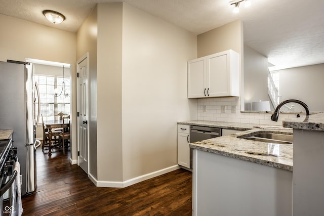 kitchen with a sink, light stone counters, tasteful backsplash, freestanding refrigerator, and dark wood-style flooring