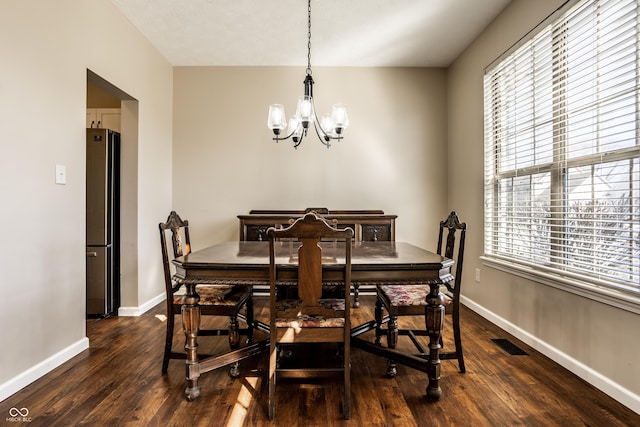 dining room featuring visible vents, plenty of natural light, dark wood-type flooring, and a chandelier