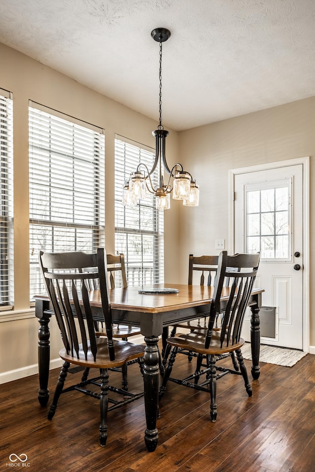 dining space featuring dark wood finished floors, a textured ceiling, and baseboards