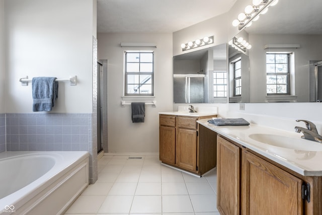 bathroom featuring a bath, tile patterned flooring, a stall shower, and vanity