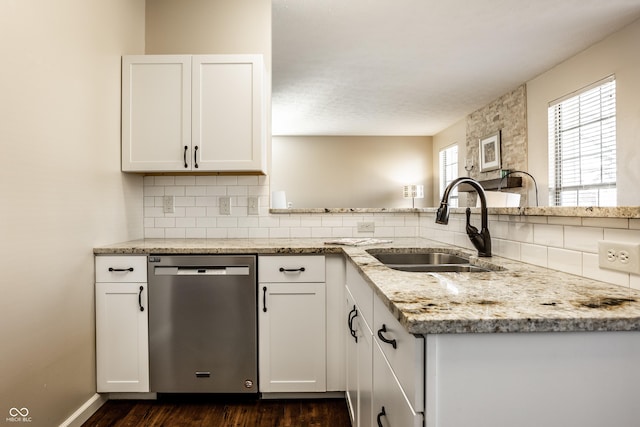 kitchen with a sink, light stone counters, tasteful backsplash, white cabinetry, and dishwasher