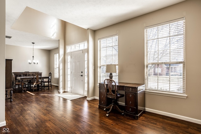 foyer with dark wood finished floors, visible vents, a chandelier, and baseboards