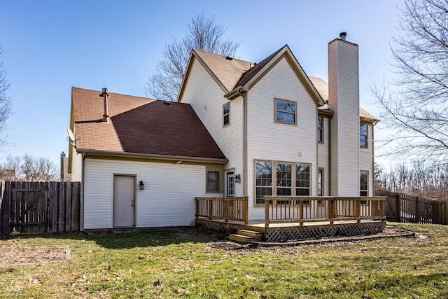 rear view of house featuring a deck, a yard, fence, and a chimney