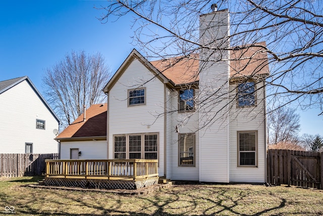 rear view of property featuring a wooden deck, a fenced backyard, a shingled roof, a chimney, and a lawn