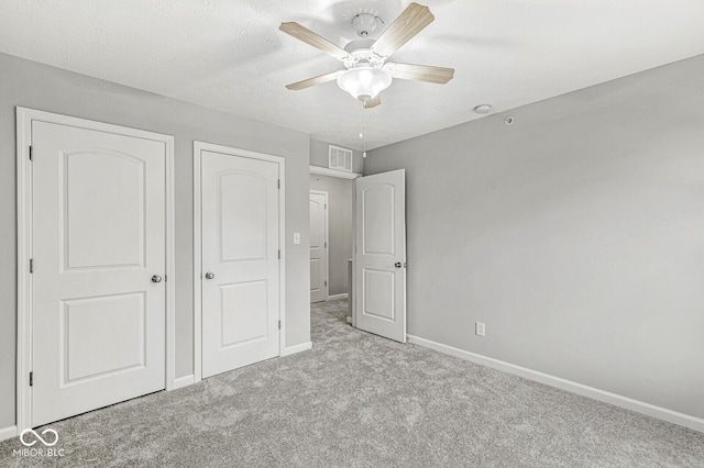 unfurnished bedroom featuring a ceiling fan, carpet flooring, baseboards, and visible vents