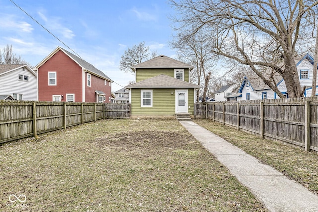 back of house with a yard, a residential view, a fenced backyard, and entry steps