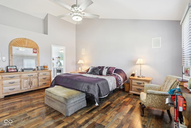 bedroom with a ceiling fan, ensuite bath, dark wood-style flooring, and vaulted ceiling