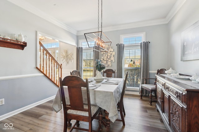 dining space with crown molding, baseboards, a chandelier, stairway, and wood finished floors