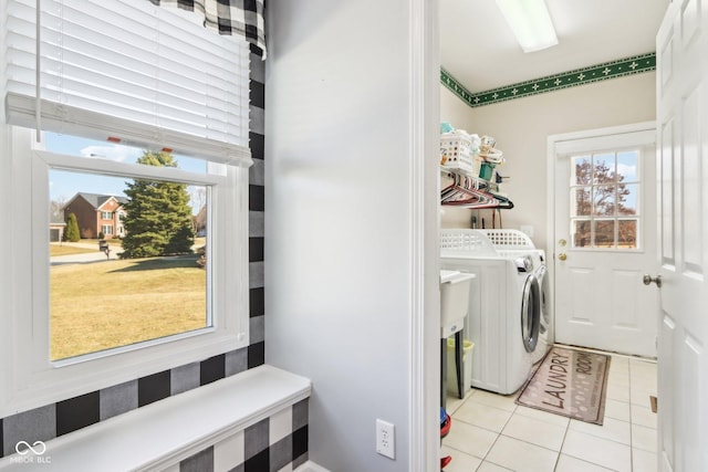 clothes washing area with washer and clothes dryer, laundry area, and light tile patterned floors