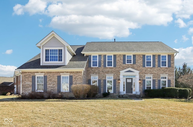 colonial-style house with brick siding and a front lawn