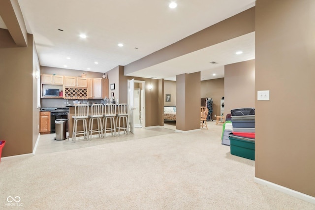 recreation room with recessed lighting, indoor wet bar, light carpet, and baseboards