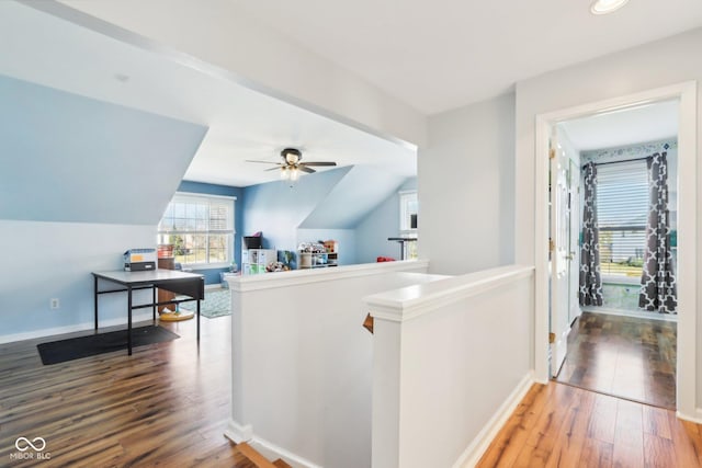 hall with baseboards, an upstairs landing, lofted ceiling, and wood-type flooring