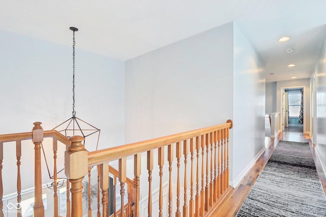 hallway with wood finished floors, recessed lighting, an upstairs landing, and baseboards