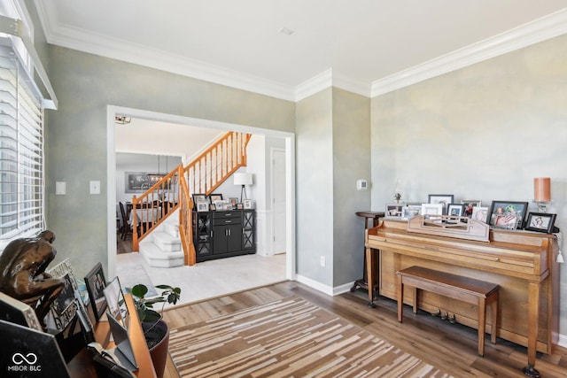 interior space featuring stairway, ornamental molding, baseboards, and wood finished floors