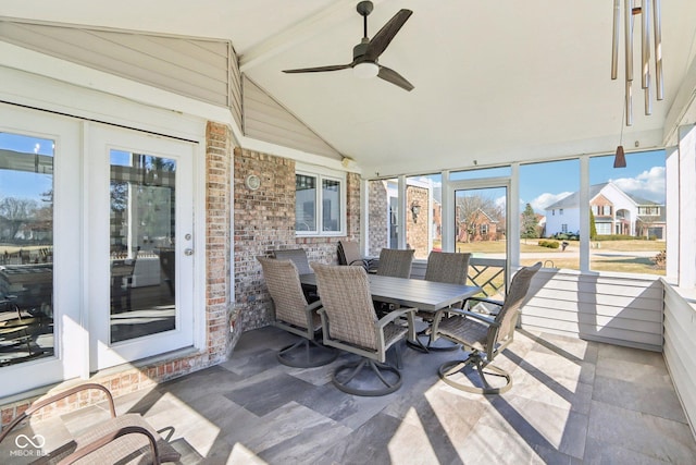 sunroom / solarium featuring lofted ceiling with beams and a ceiling fan