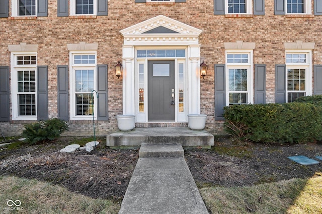 entrance to property featuring brick siding