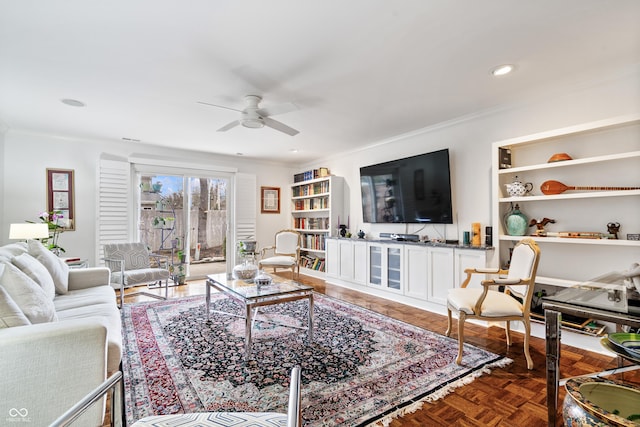 living area with recessed lighting, built in features, ornamental molding, and a ceiling fan