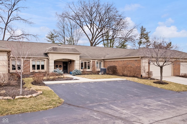 view of front of home featuring aphalt driveway, brick siding, a garage, and a shingled roof