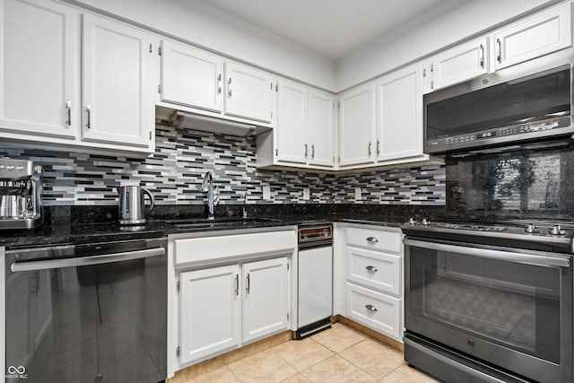 kitchen with a sink, white cabinets, backsplash, and stainless steel appliances