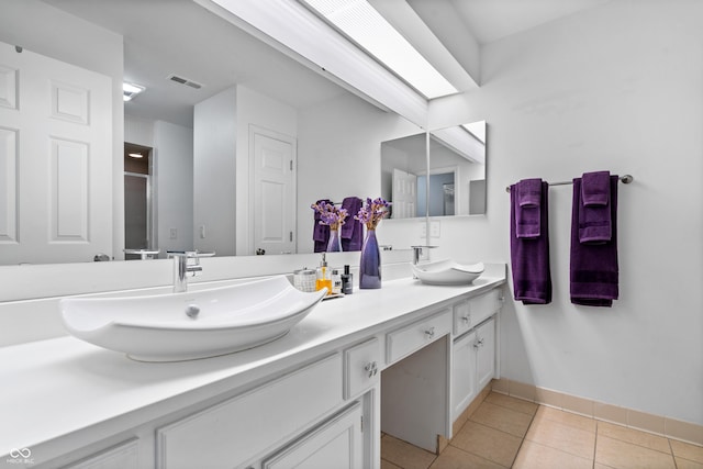 full bath with a sink, visible vents, double vanity, and tile patterned flooring