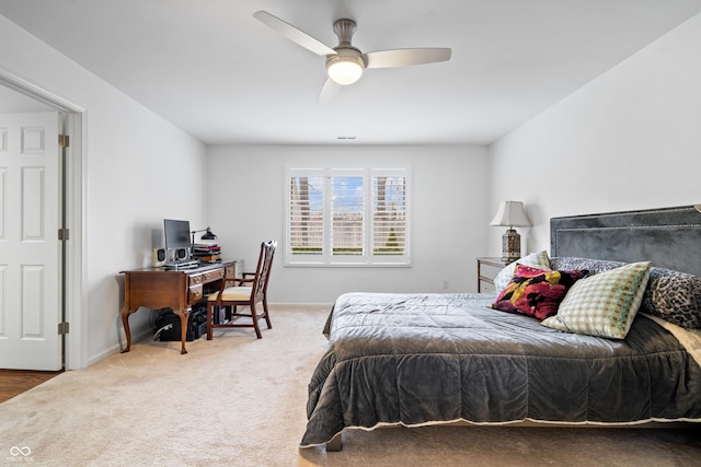 carpeted bedroom with ceiling fan and baseboards