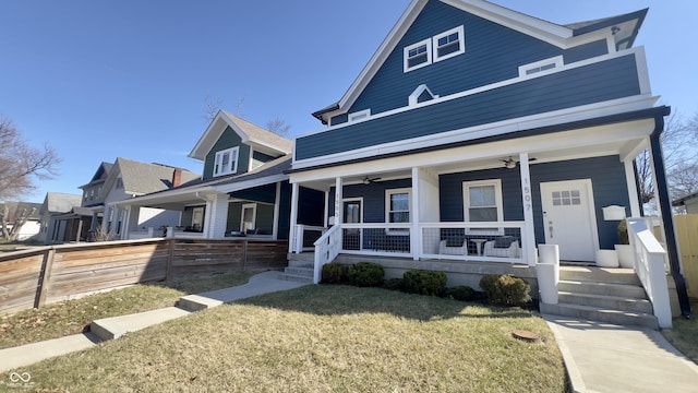 view of front of house featuring a front lawn, covered porch, a ceiling fan, and fence