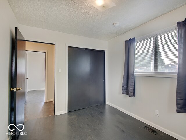 2955 Mars Hill St, Indianapolis, IN 46241 - unfurnished bedroom with baseboards, a textured ceiling, wood finished floors, and a closet