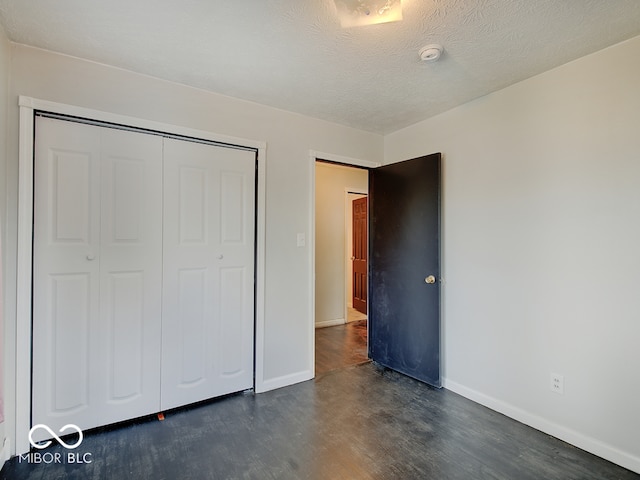 2955 Mars Hill St, Indianapolis, IN 46241 - unfurnished bedroom with dark wood finished floors, baseboards, a closet, and a textured ceiling