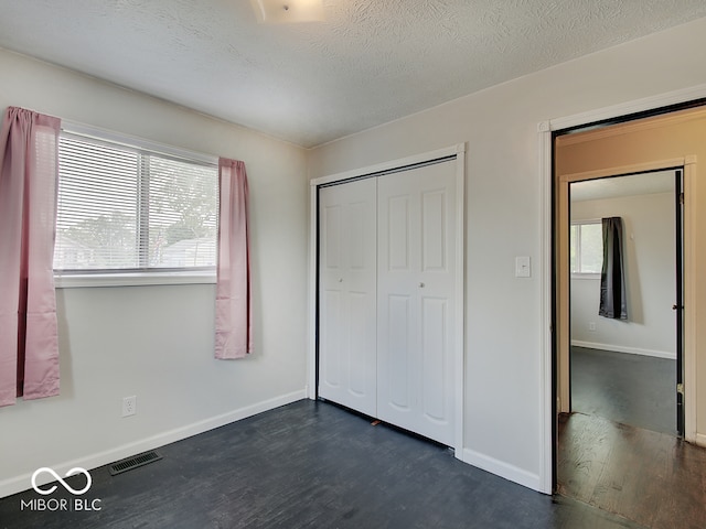 2955 Mars Hill St, Indianapolis, IN 46241 - unfurnished bedroom with dark wood-type flooring, baseboards, a closet, and a textured ceiling