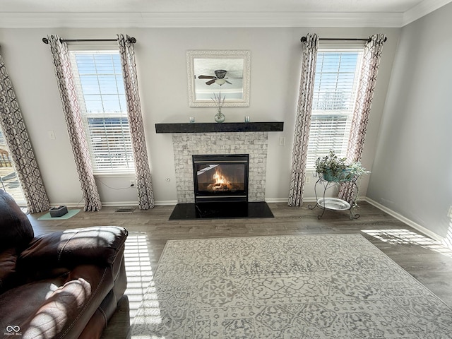 living area featuring a wealth of natural light, ornamental molding, and a fireplace